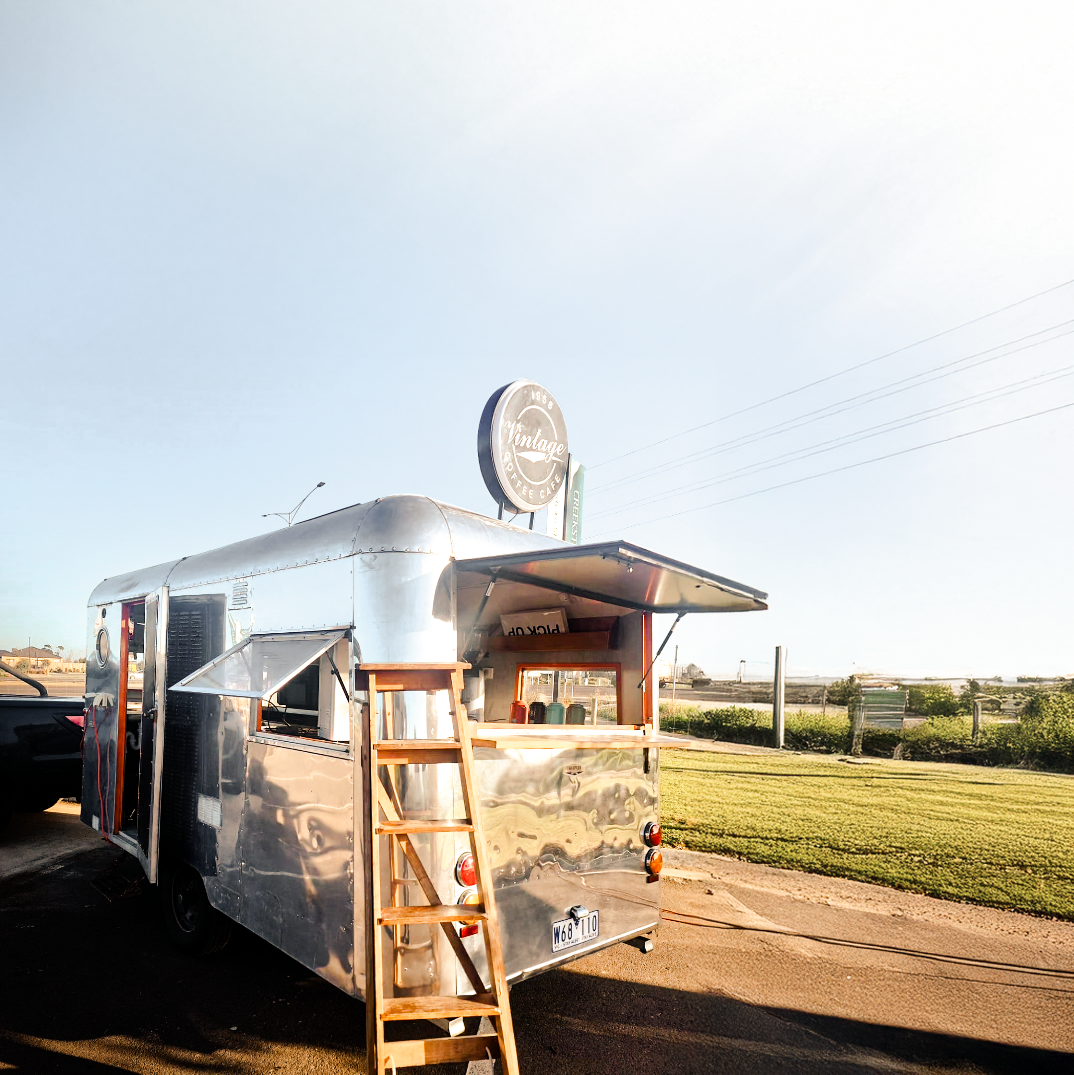 The Carapark — a 1958 silver Carapark trailer parked by the coast at sunrise